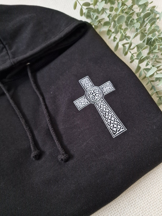 Black hoodie with white embroidered Celtic cross and intricate patterns on the front.